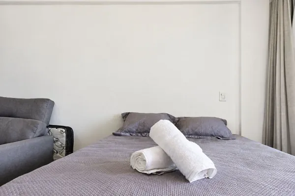 Cama queen com travesseiros e toalhas
